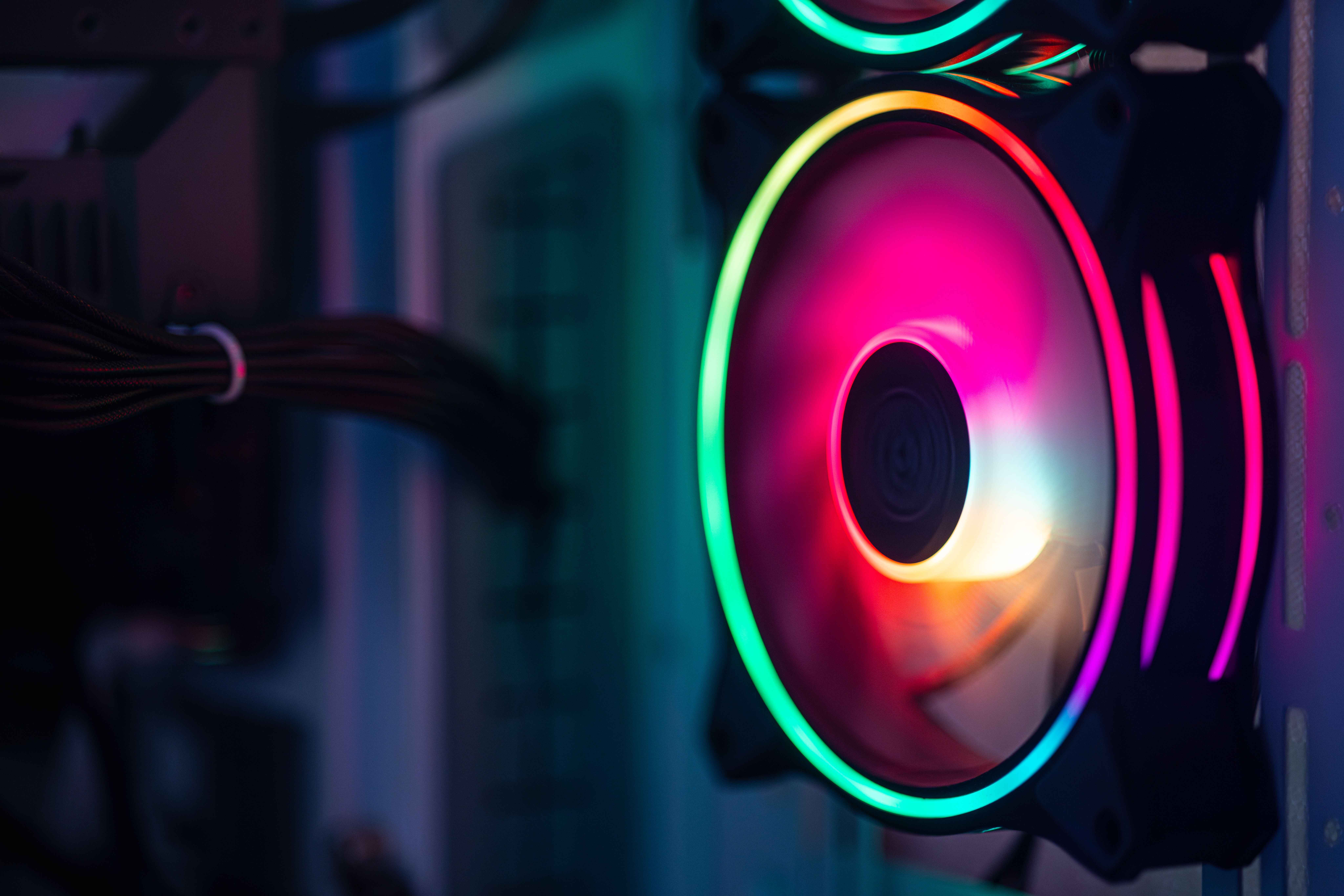 Close-up of a colorful RGB cooling fan in a gaming PC setup.