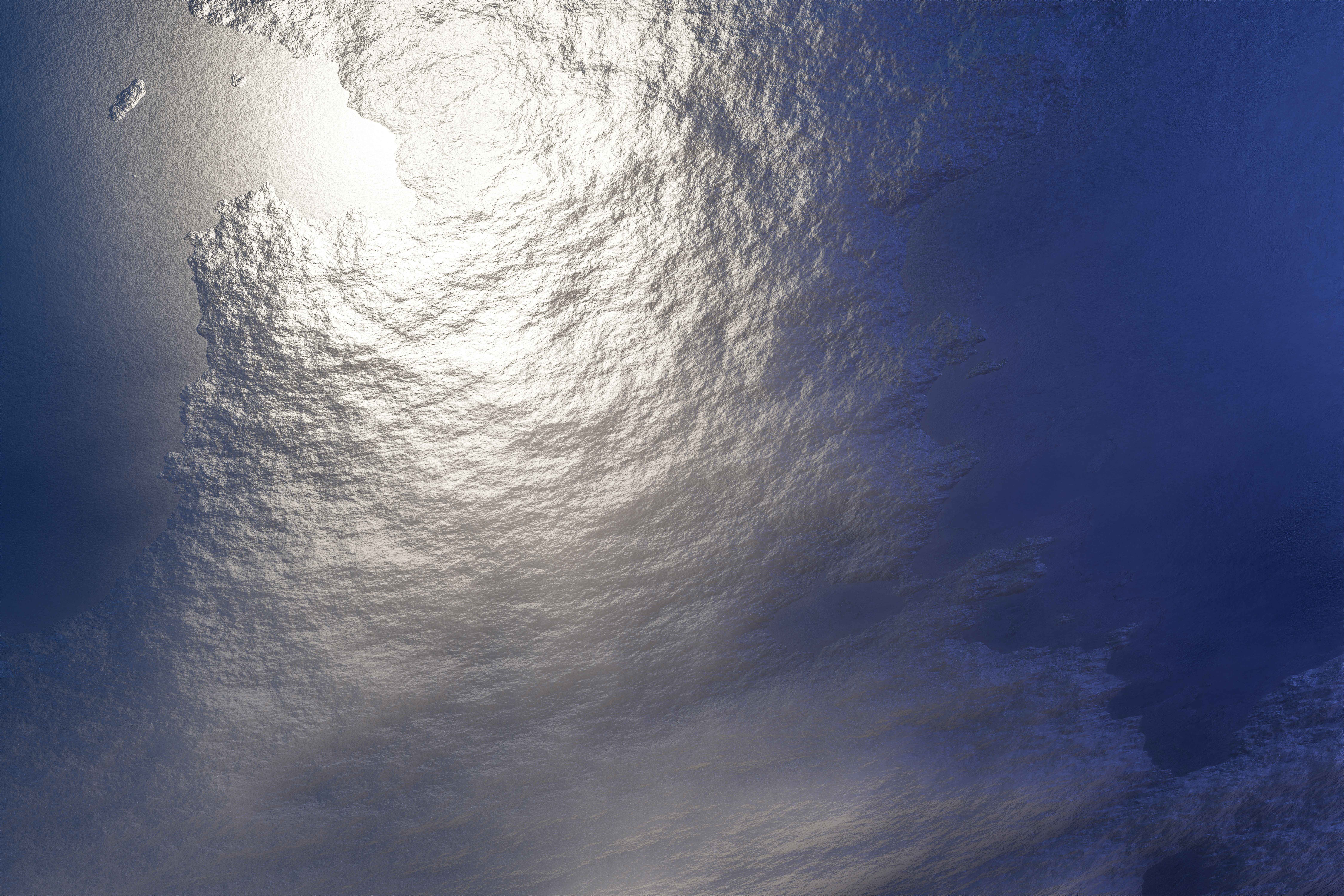 A serene aerial shot of ocean waves reflecting sunlight, creating a tranquil and peaceful atmosphere.