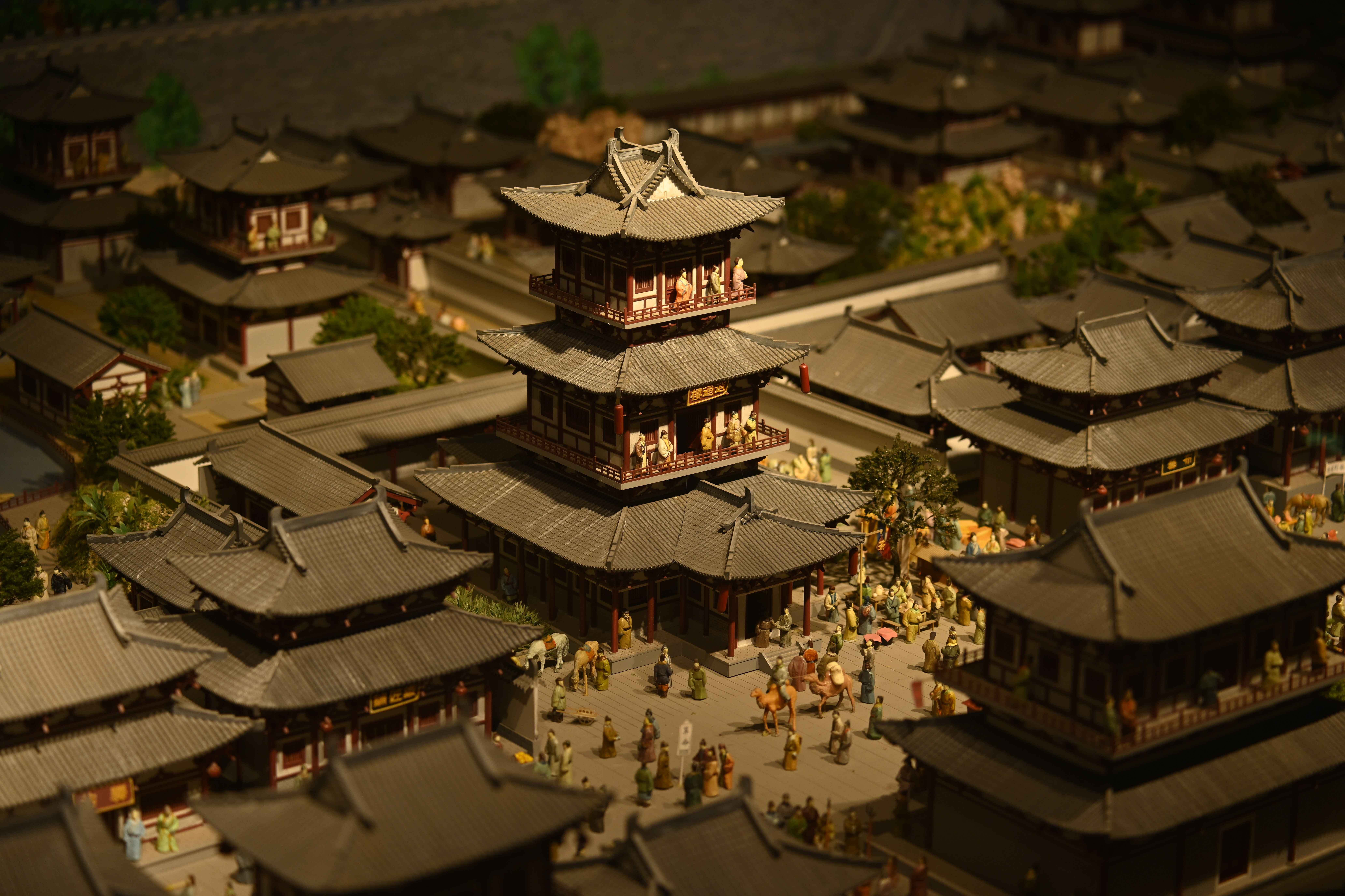 Detailed miniature model depicting traditional Asian architecture in a historical scene.